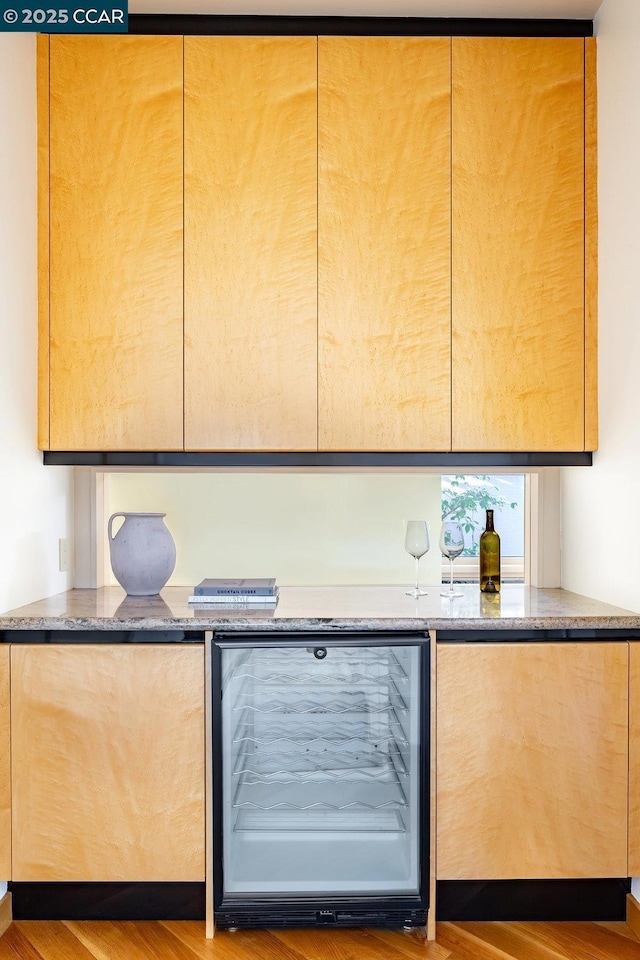 interior space with dark stone countertops, dark hardwood / wood-style floors, and wine cooler