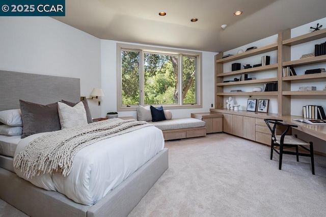 carpeted bedroom featuring built in desk