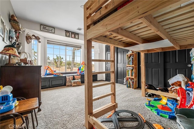 rec room featuring carpet and beam ceiling