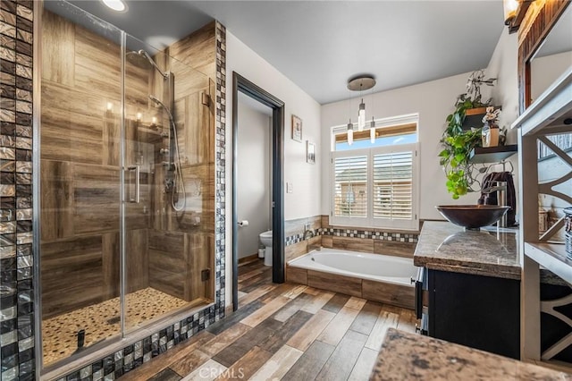 full bathroom featuring toilet, shower with separate bathtub, and vanity