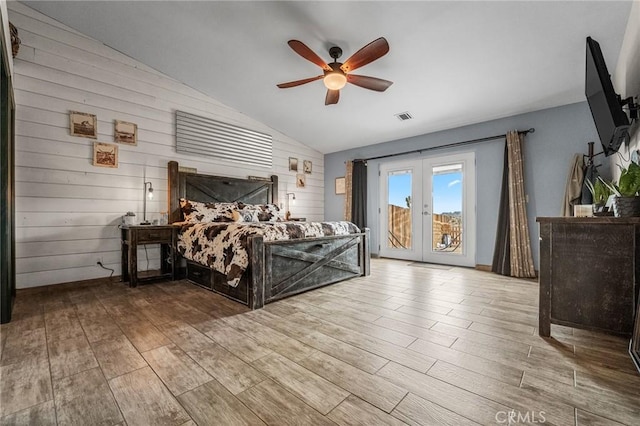 bedroom featuring ceiling fan, french doors, access to outside, wooden walls, and lofted ceiling