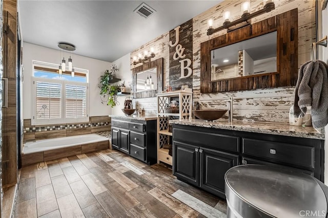 bathroom with tiled bath and vanity