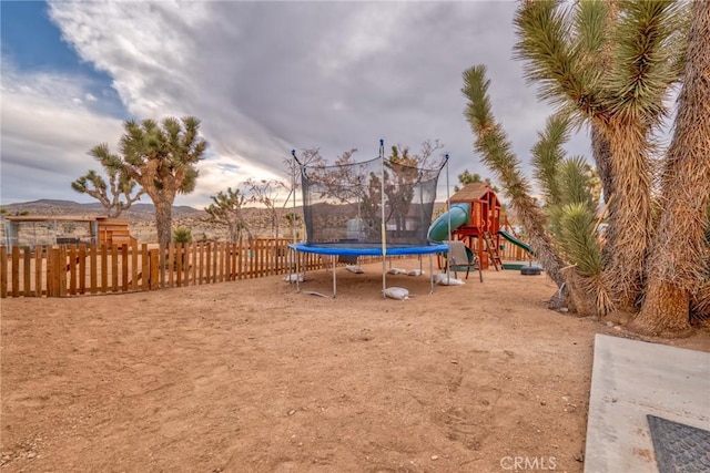 view of playground featuring a mountain view and a trampoline