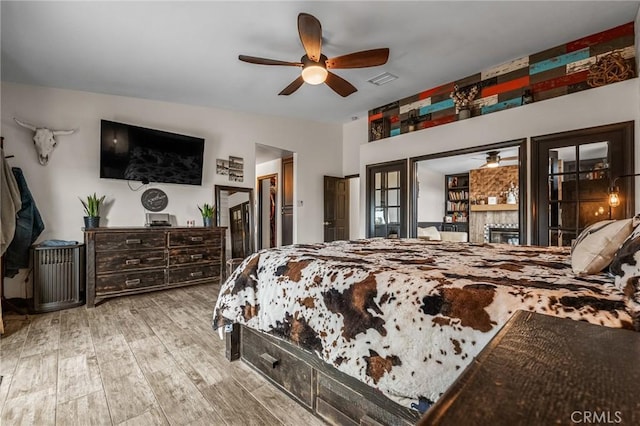 bedroom featuring ceiling fan, light hardwood / wood-style flooring, and lofted ceiling