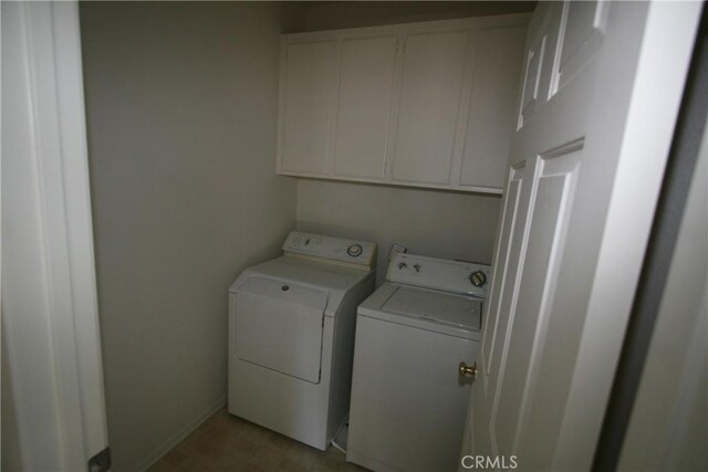 washroom featuring cabinets and separate washer and dryer