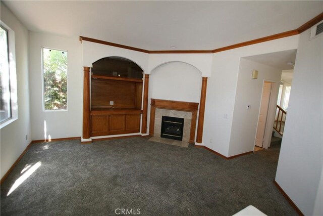 unfurnished living room with a fireplace and dark colored carpet