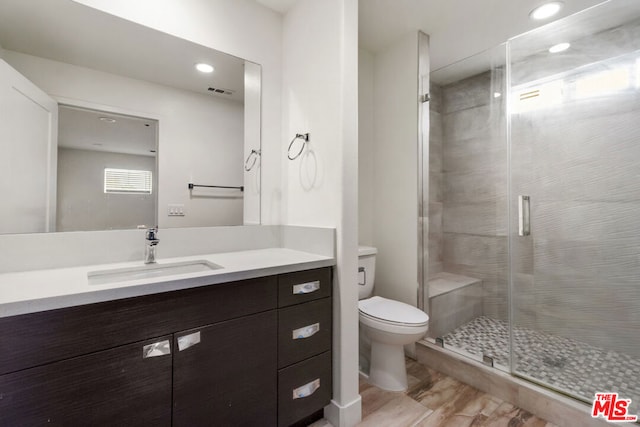 bathroom featuring vanity, walk in shower, and toilet