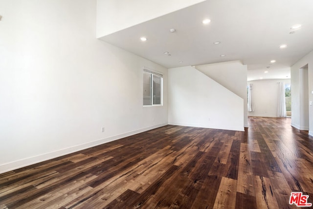 unfurnished living room with dark hardwood / wood-style flooring