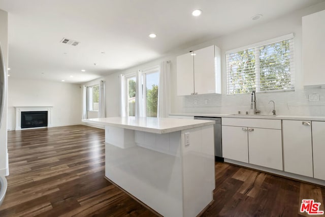 kitchen featuring sink, dishwasher, white cabinetry, dark hardwood / wood-style floors, and a kitchen island