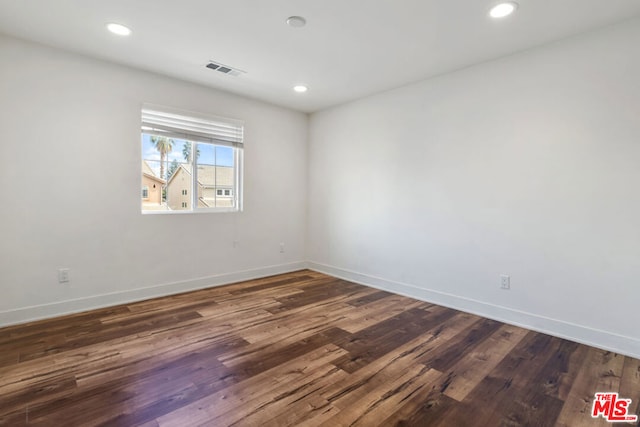 spare room featuring dark wood-type flooring