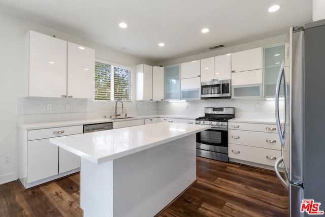 kitchen featuring white cabinetry, appliances with stainless steel finishes, a center island, and dark hardwood / wood-style floors