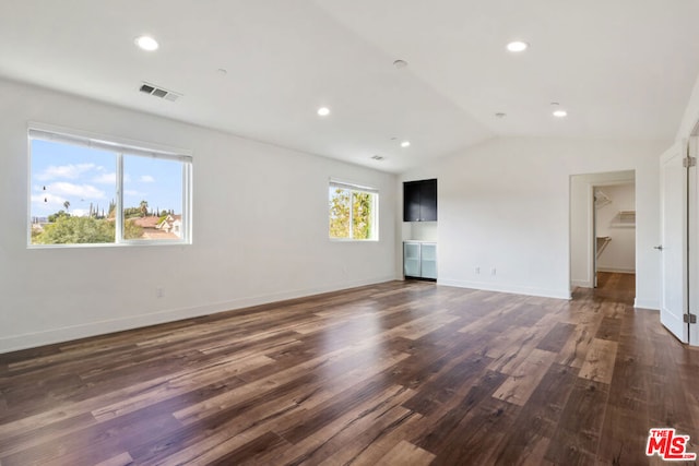 spare room with lofted ceiling and dark hardwood / wood-style flooring