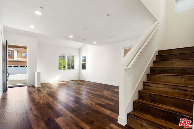 interior space featuring dark wood-type flooring and vaulted ceiling