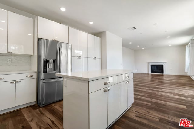 kitchen with white cabinetry, a center island, dark wood-type flooring, and stainless steel fridge