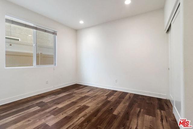 empty room with dark hardwood / wood-style flooring