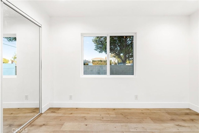 empty room with baseboards and wood finished floors