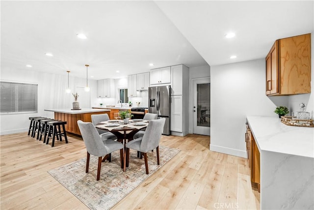 dining room with sink and light hardwood / wood-style floors