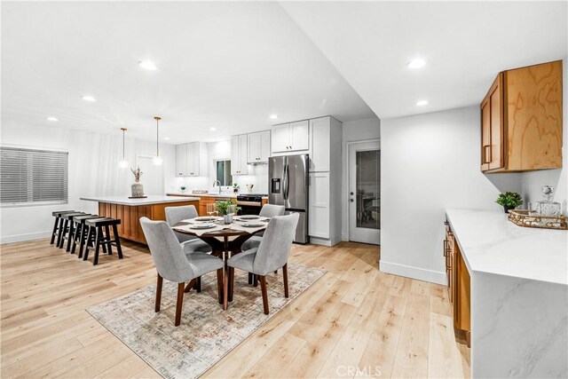 dining room with recessed lighting, light wood-style floors, and baseboards