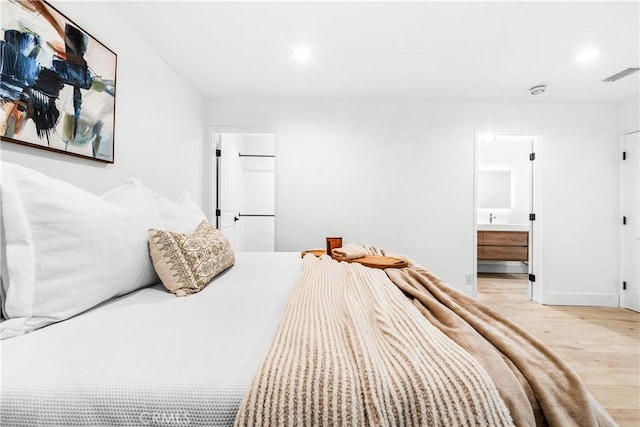 bedroom with visible vents, baseboards, recessed lighting, light wood-style flooring, and ensuite bath