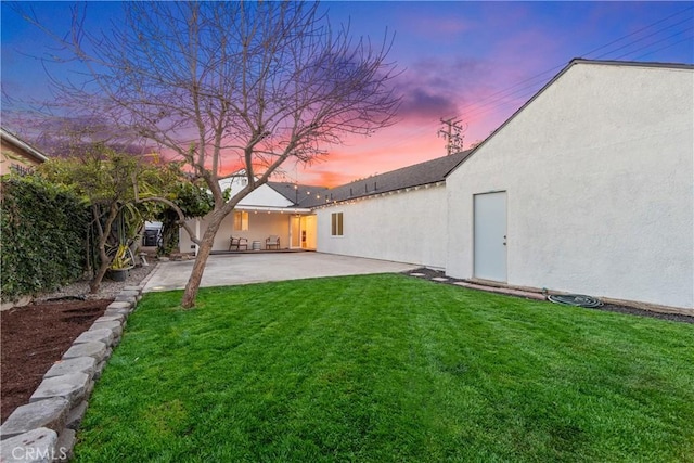 yard at dusk with a patio area