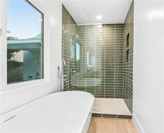 bathroom featuring independent shower and bath and hardwood / wood-style floors