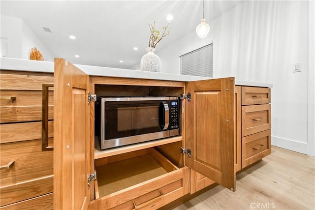 details with baseboards, visible vents, light wood-style flooring, recessed lighting, and stainless steel microwave