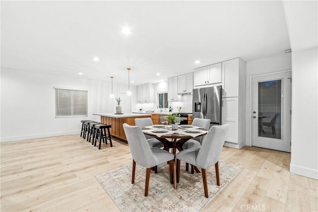 dining area with recessed lighting, baseboards, and light wood finished floors