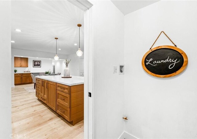 kitchen with decorative light fixtures and light wood-type flooring