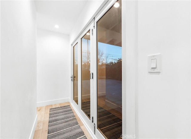 hall featuring recessed lighting, baseboards, and wood finished floors