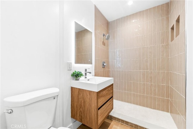 full bath with tiled shower, toilet, and vanity