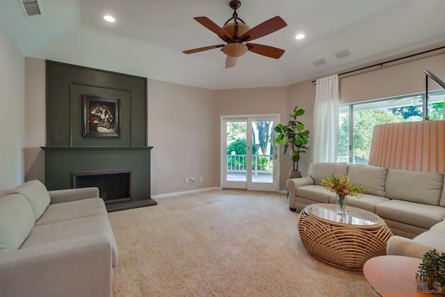 carpeted living room with a large fireplace and ceiling fan