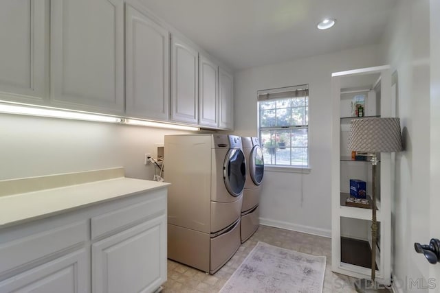 washroom featuring cabinets and washer and dryer