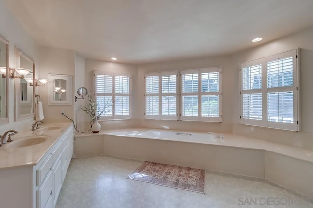 bathroom featuring vanity, a bathtub, and a healthy amount of sunlight