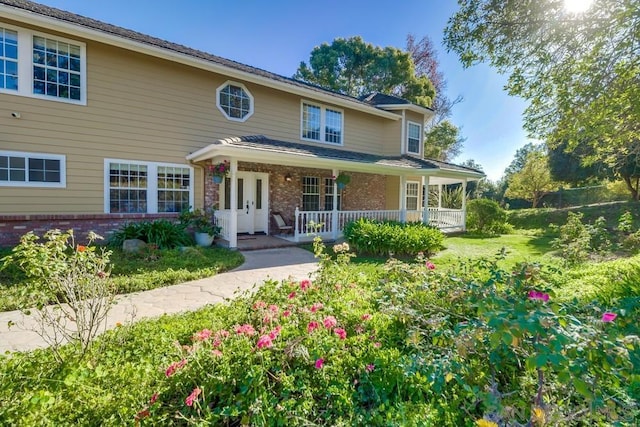 view of front of property featuring covered porch and a front yard