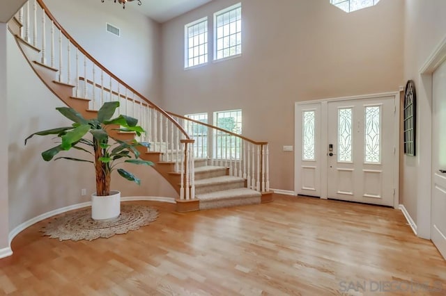 entrance foyer featuring a high ceiling, a wealth of natural light, and light hardwood / wood-style flooring