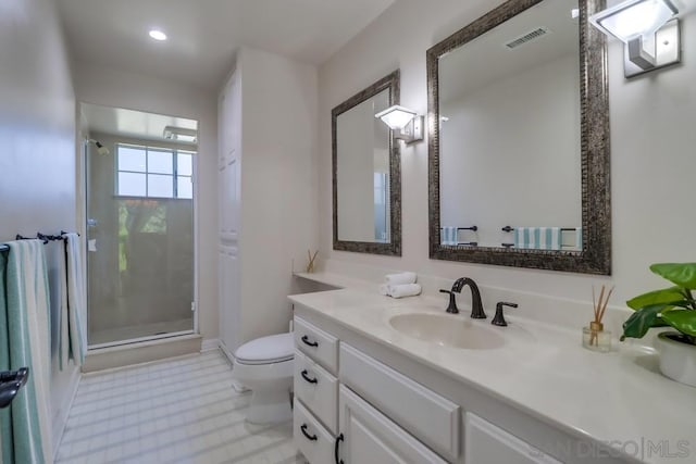 bathroom featuring toilet, a shower with shower door, and vanity