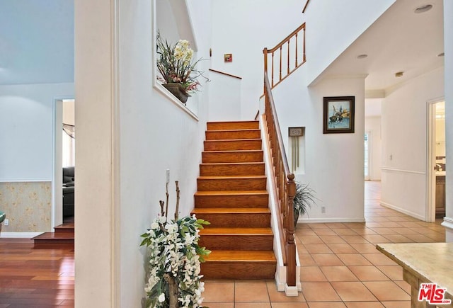 stairs featuring crown molding and tile patterned floors