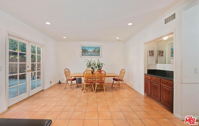 tiled dining space with crown molding and french doors