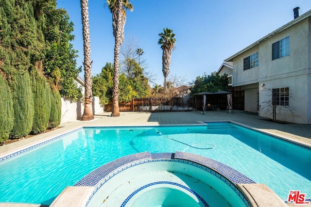 view of swimming pool with an in ground hot tub