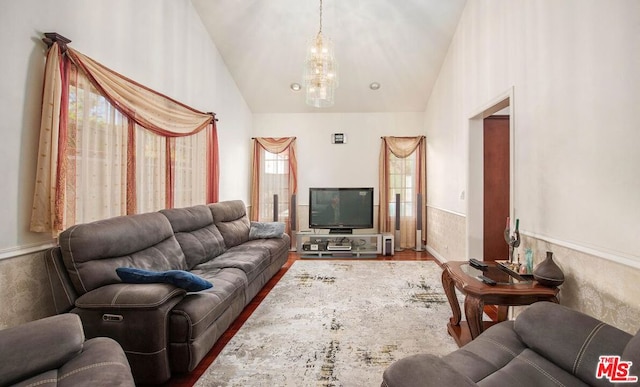 living room featuring hardwood / wood-style flooring, high vaulted ceiling, and a notable chandelier