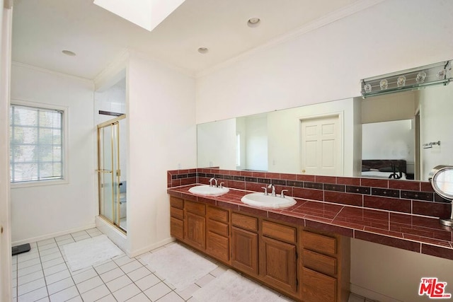 bathroom with tile patterned flooring, vanity, a skylight, decorative backsplash, and ornamental molding