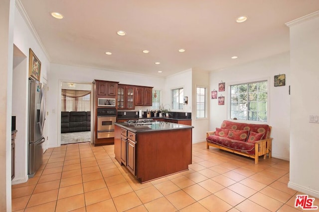 kitchen with ornamental molding, light tile patterned flooring, a center island, and stainless steel appliances