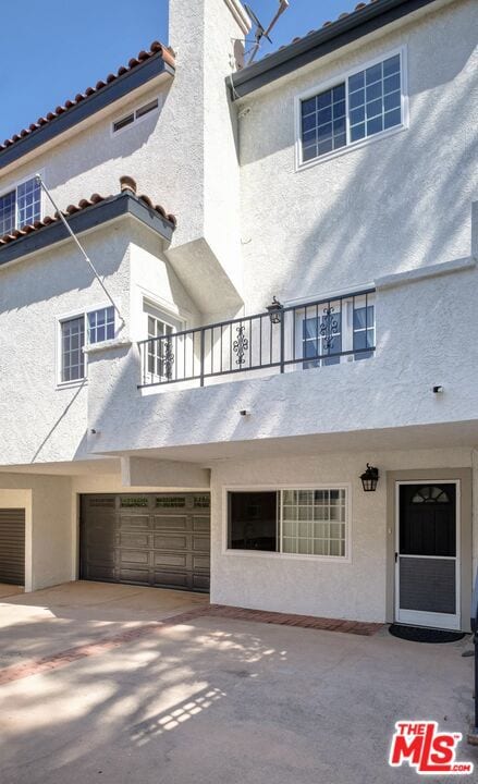 view of property with a garage and a balcony