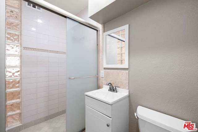 bathroom featuring vanity, tasteful backsplash, and toilet