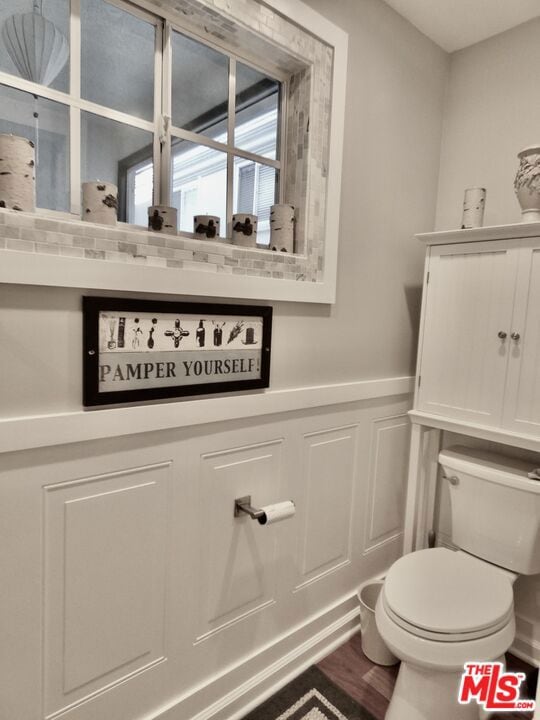 bathroom with hardwood / wood-style flooring and toilet