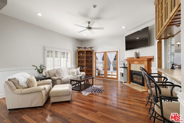 living room with ceiling fan, dark hardwood / wood-style floors, and a tile fireplace