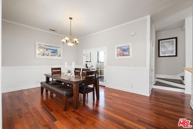 dining area featuring crown molding, dark hardwood / wood-style flooring, a chandelier, and french doors