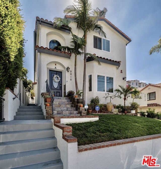 mediterranean / spanish-style house with a front yard