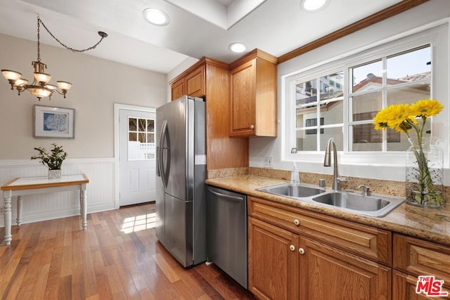 kitchen featuring dark hardwood / wood-style floors, pendant lighting, sink, a notable chandelier, and stainless steel appliances