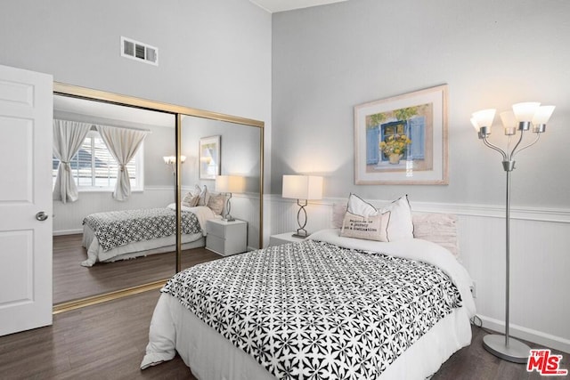 bedroom with dark hardwood / wood-style flooring, a notable chandelier, and a closet